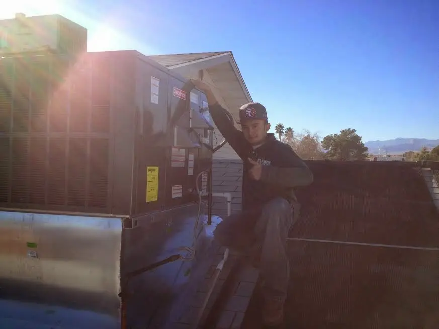HVAC technician performing HVAC Inspection on a rooftop unit in Waterford